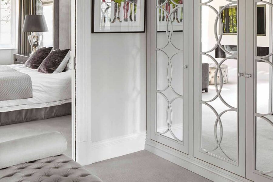 Mirrored wardrobe in master bedroom with luxury ottoman seating