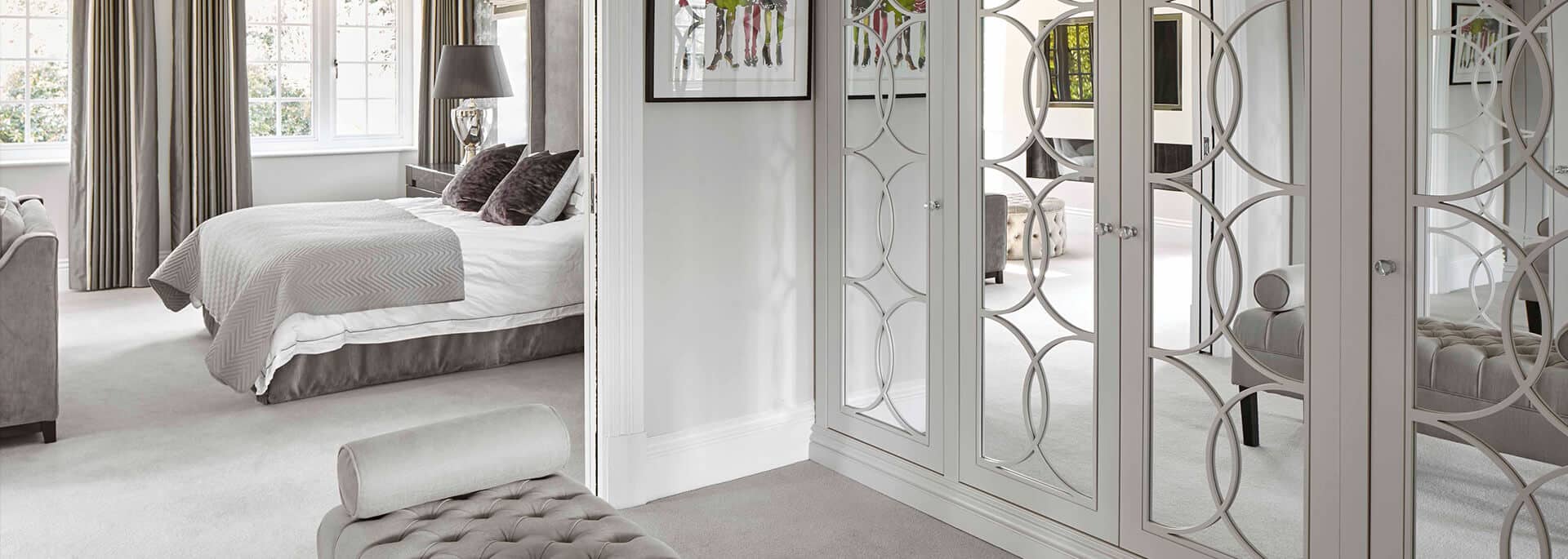 Mirrored wardrobe in master bedroom with luxury ottoman seating