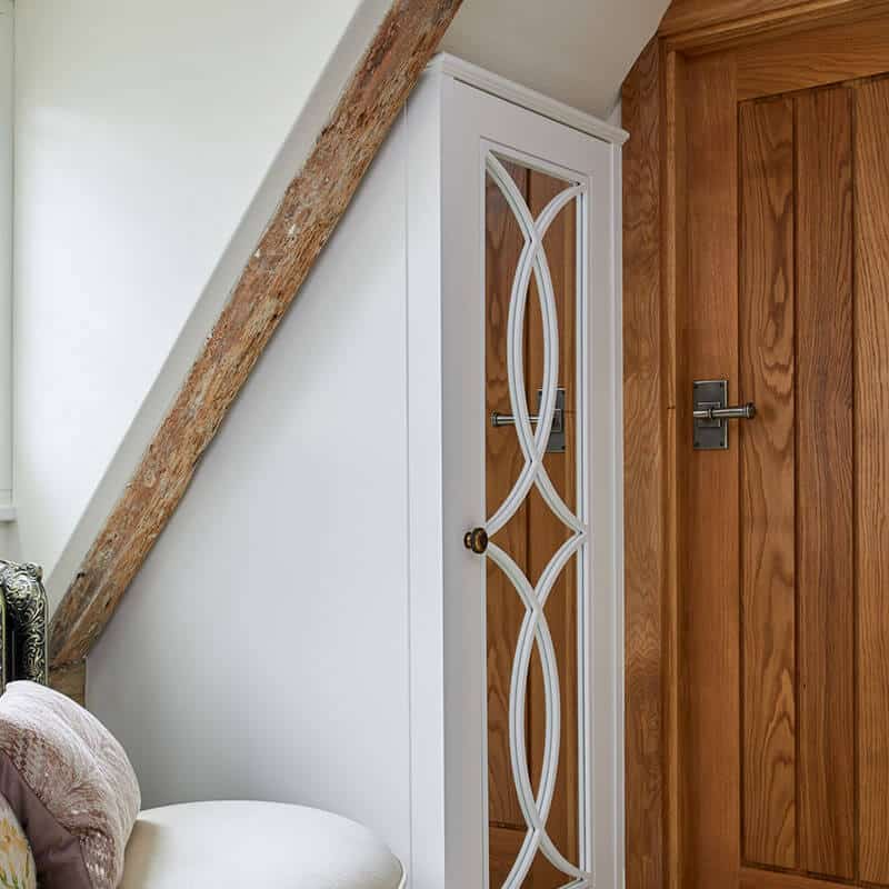 A wooden design on a white wall and a classically designed door