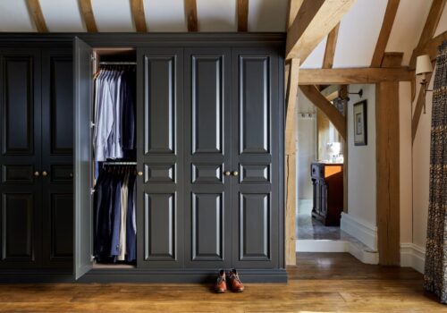 Organised walk-in wardrobe with sections for shoes, handbags, and neatly folded clothes