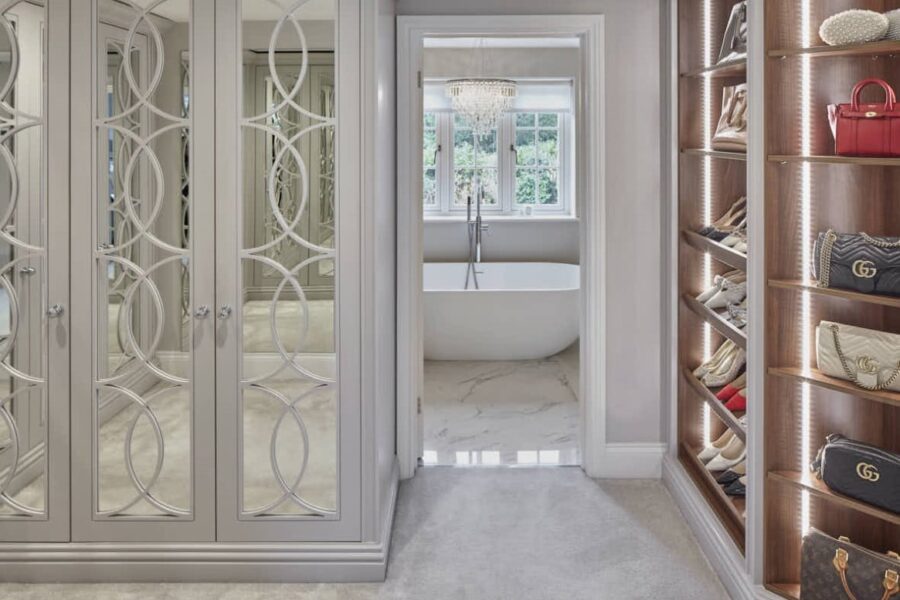 Bespoke fitted wardrobes and shelving with door leading into bathroom
