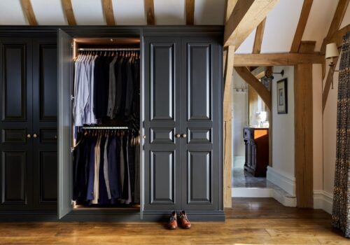 Fully customised fitted wardrobe with a closet and clothes hanging in it