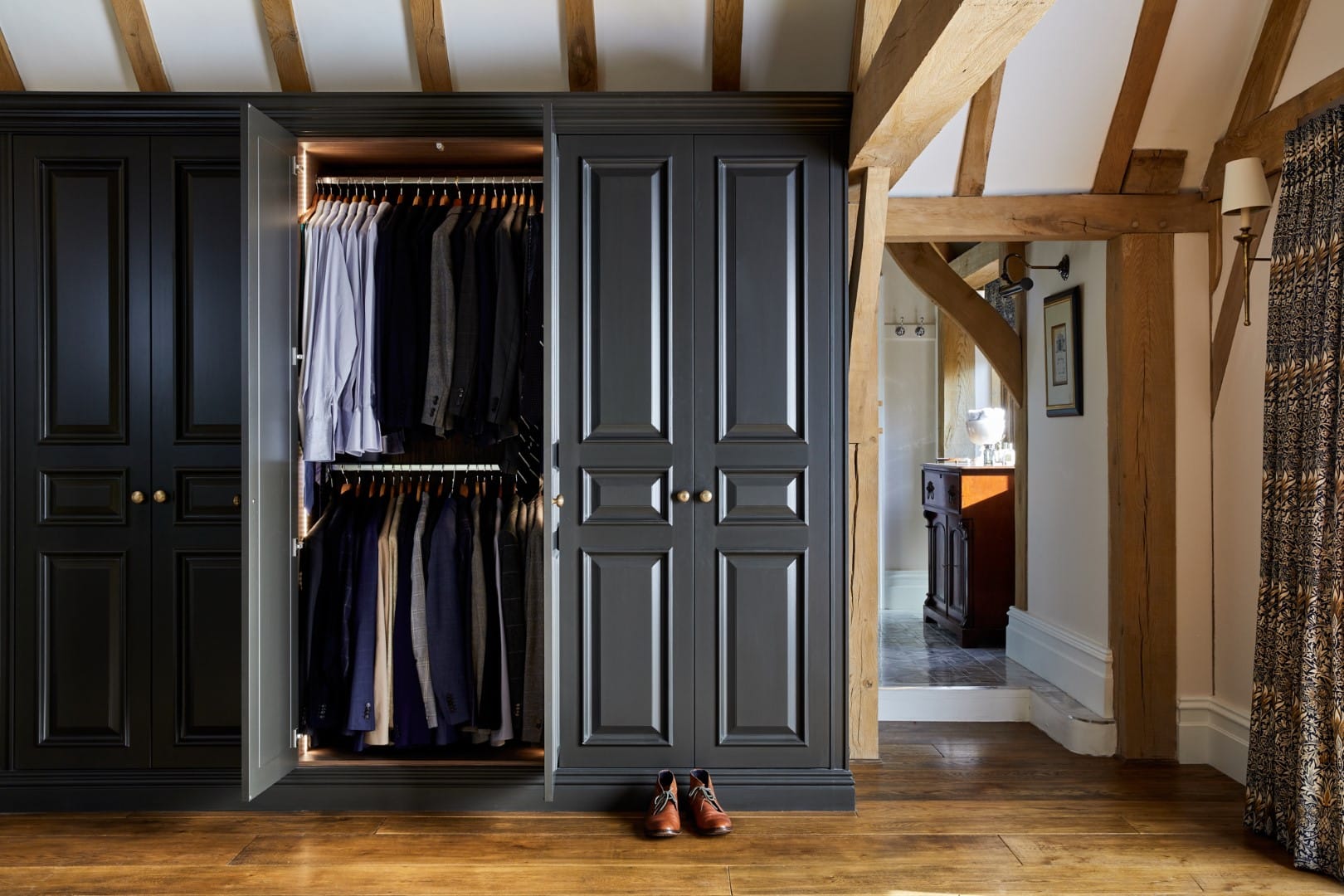 Fully customised fitted wardrobe with a closet and clothes hanging in it