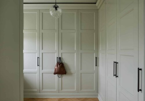 Edwardian fitted wardrobe with handbag hanging on the black handles
