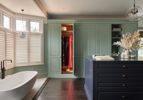 Jubilee fitted wardrobes with doors open and internal lighting. with island in blue