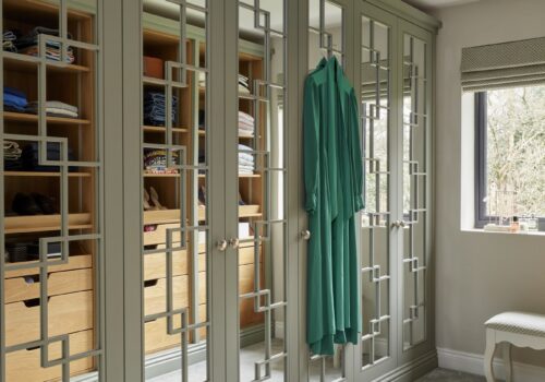 White mirrored Wentworth fitted wardrobe with open shelving opposite that is reflected in mirrored doors