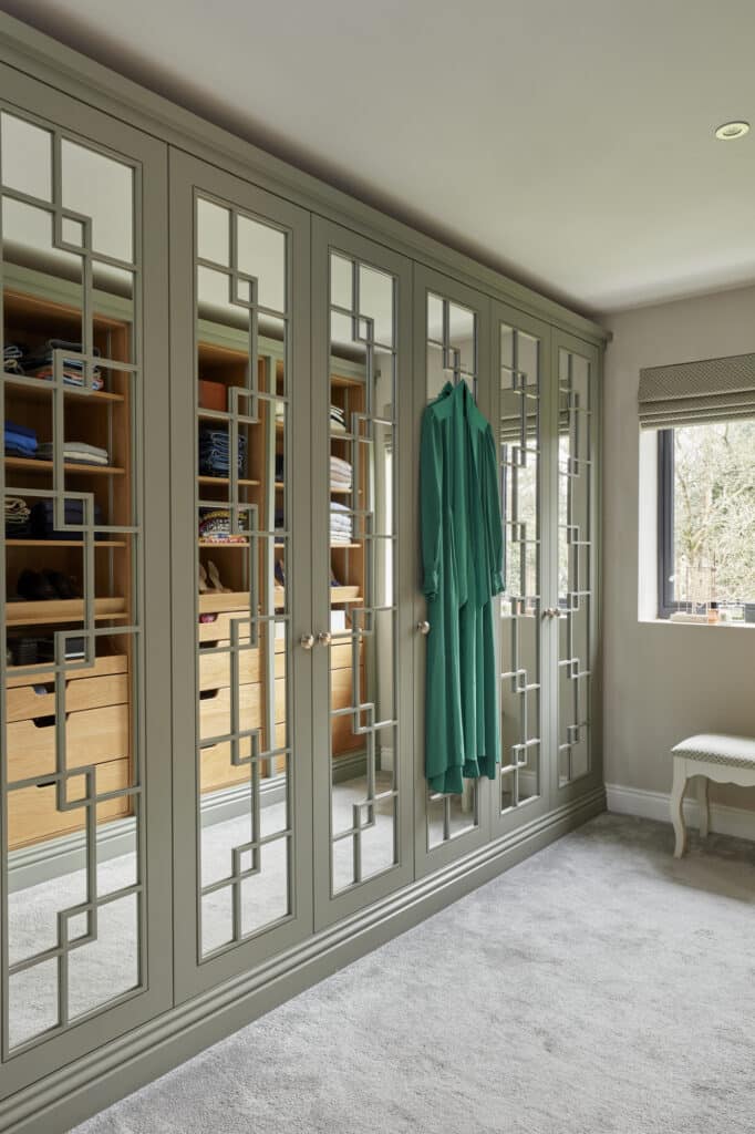 Woking - Wilson 26 White mirrored Wentworth fitted wardrobe with open shelving opposite that is reflected in mirrored doors