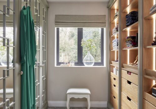 White mirrored Wentworth fitted wardrobe with open shelving opposite - lights on