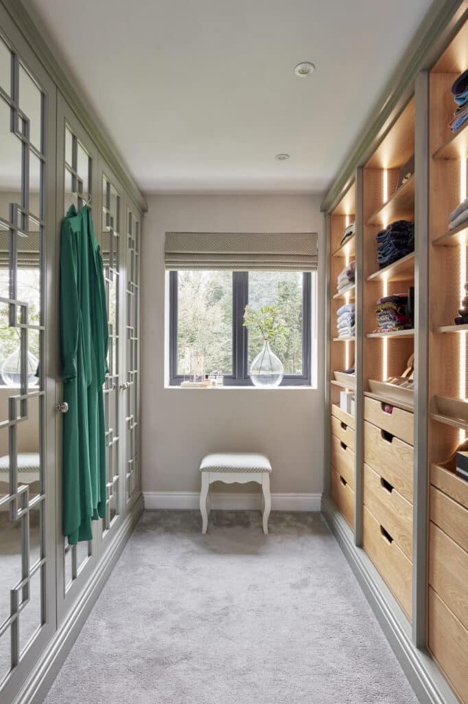 Woking - Wilson 29 White mirrored Wentworth fitted wardrobe with open shelving opposite - lights on