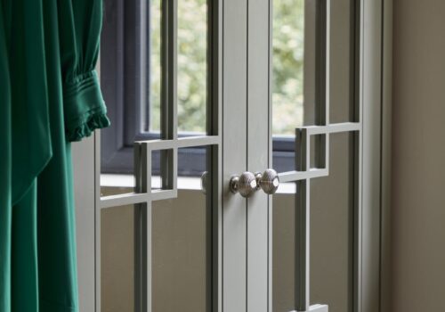 clowse-up of White mirrored Wentworth fitted wardrobe with green dress hanging