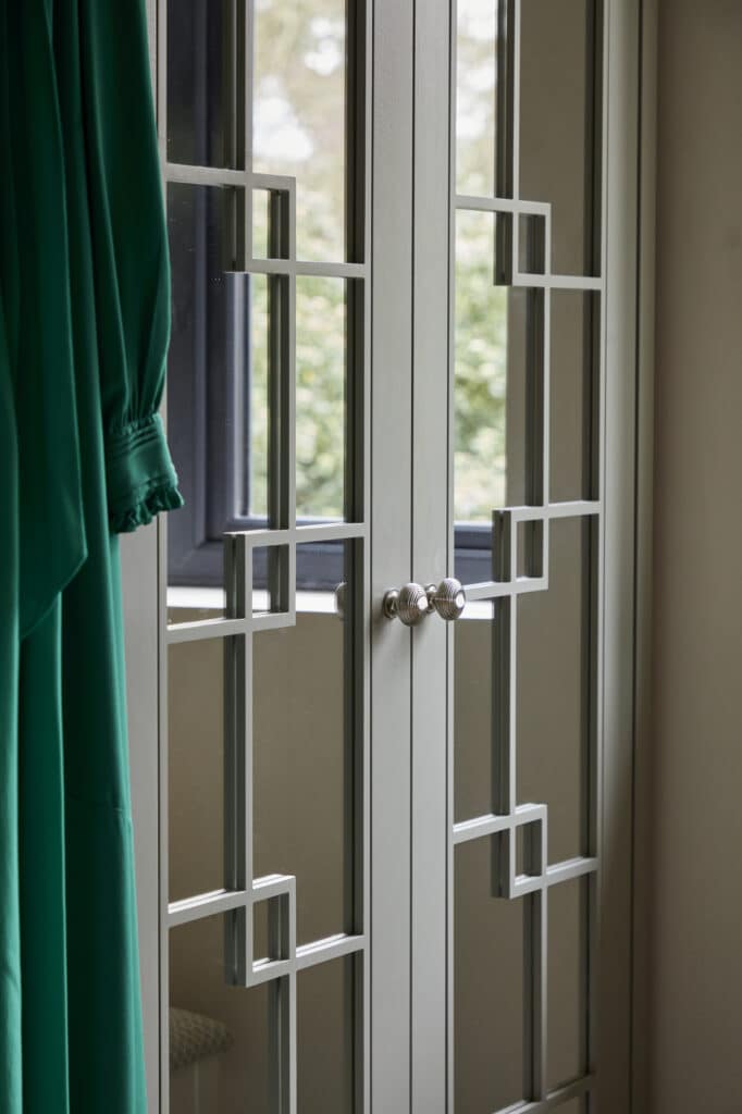 Woking - Wilson 38 clowse-up of White mirrored Wentworth fitted wardrobe with green dress hanging