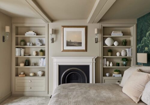 Matching Victorian style built-in shelving either side of fireplace in a bedroom - with light off