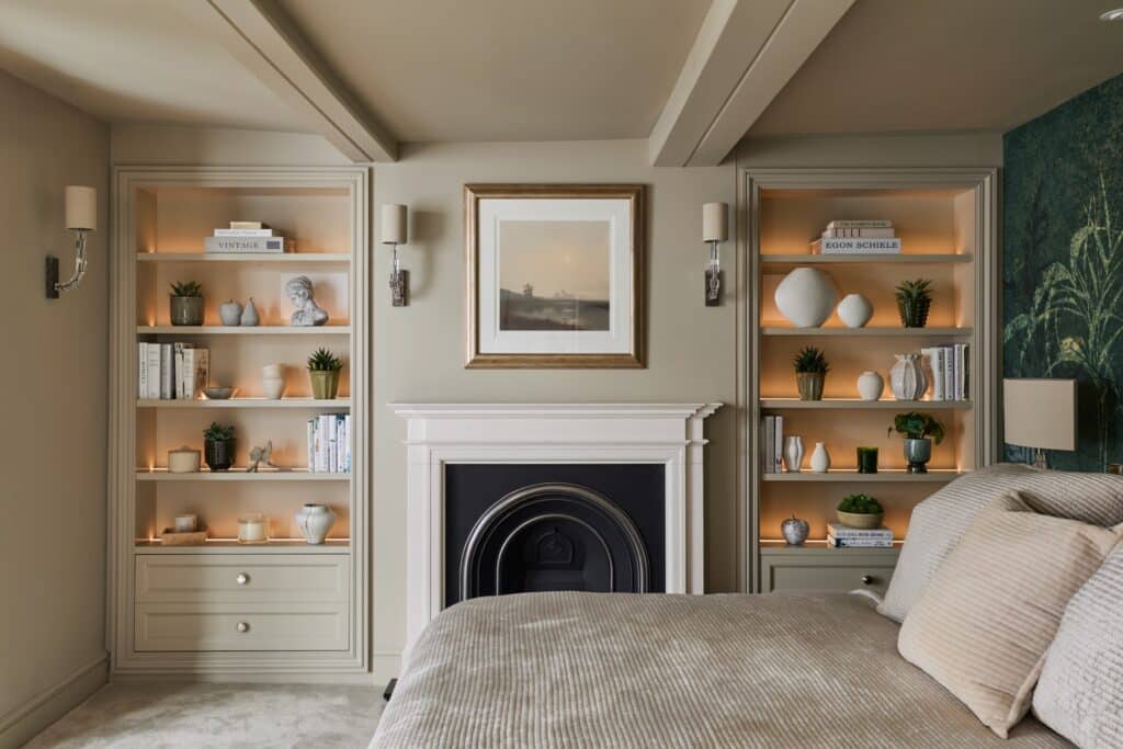 Heritage Wardrobes - Wall Hall4031-2160x1440 Matching Victorian style built-in shelving either side of fireplace in a bedroom - with dimmed light on