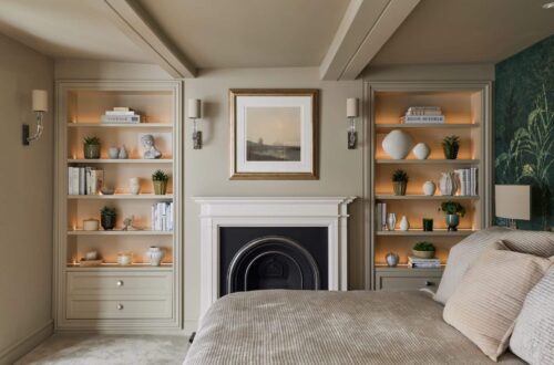 Matching Victorian style built-in shelving either side of fireplace in a bedroom - with dimmed light on