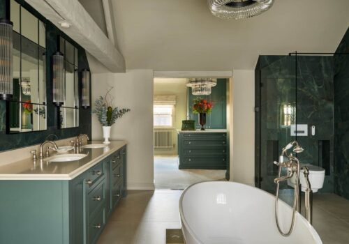 Fitted Wardrobes and hers sinks and bath tub in an ensuite bathroom, looking through to a custom built dressing room with island