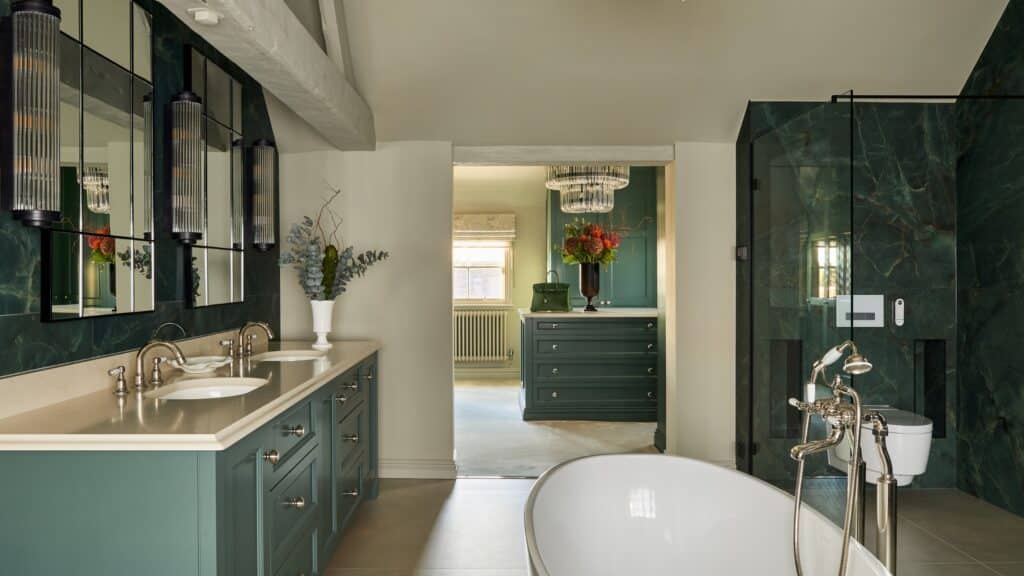 Fitted Wardrobes and hers sinks and bath tub in an ensuite bathroom, looking through to a custom built dressing room with island