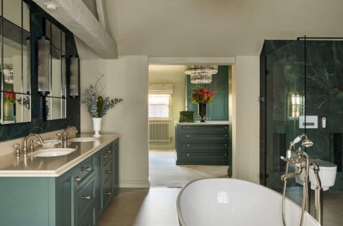 Fitted Wardrobes and hers sinks and bath tub in an ensuite bathroom, looking through to a custom built dressing room with island