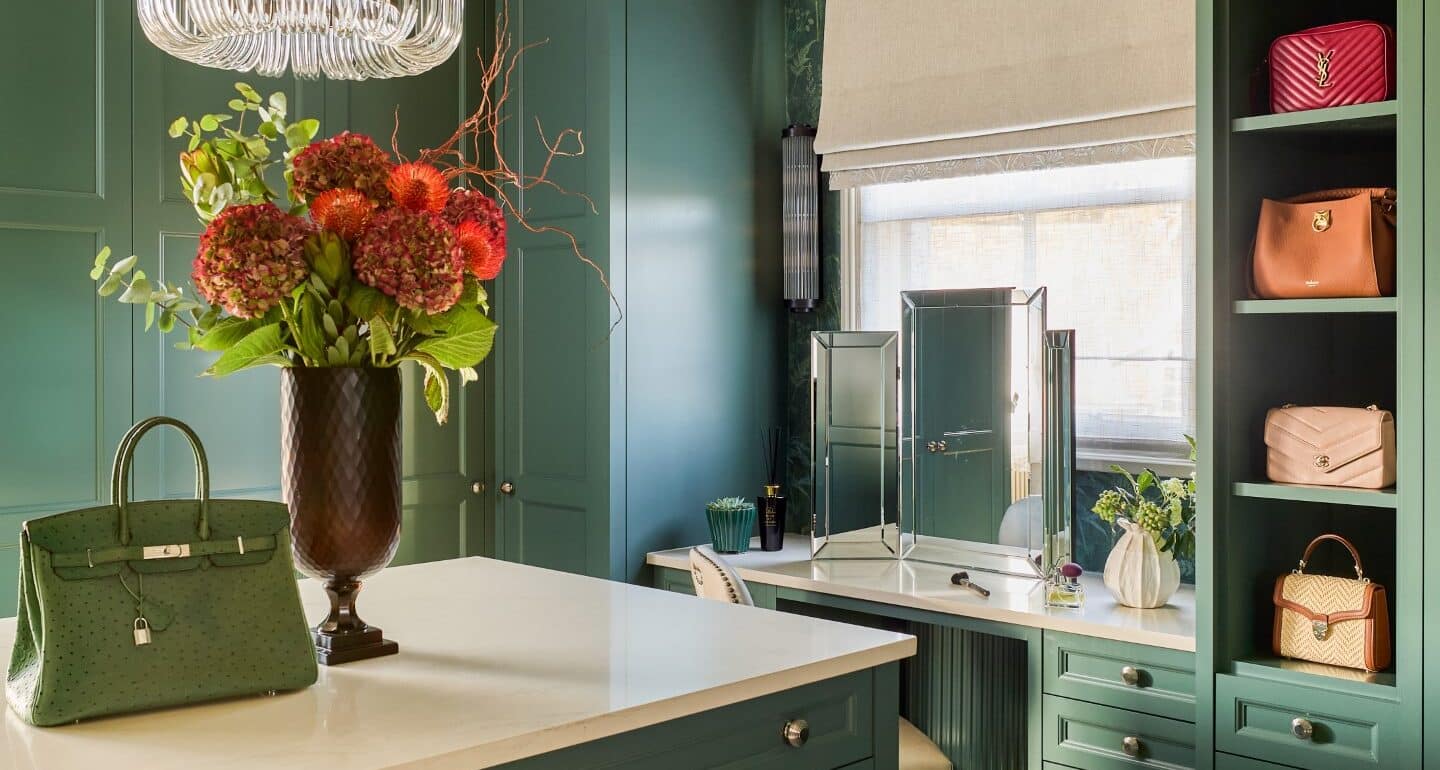 Green, Victorian style dressing room with built-in dressing table and island and open-fronted shelving