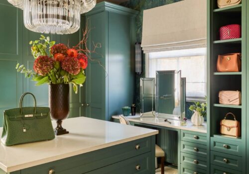 Green, Victorian style dressing room with built-in dressing table and island and open-fronted shelving