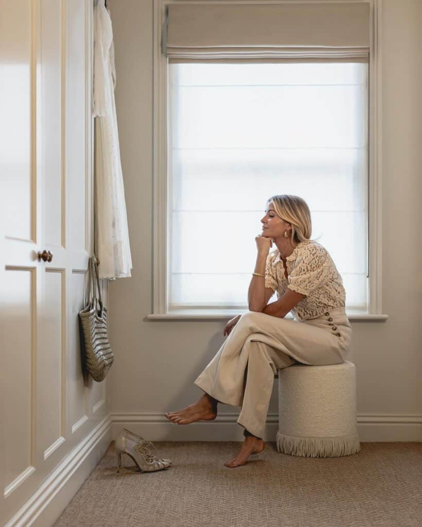 Millie Mackintosh sitting in front of her Tilford style fitted wardrobes created by The Heritage Wardrobe Company
