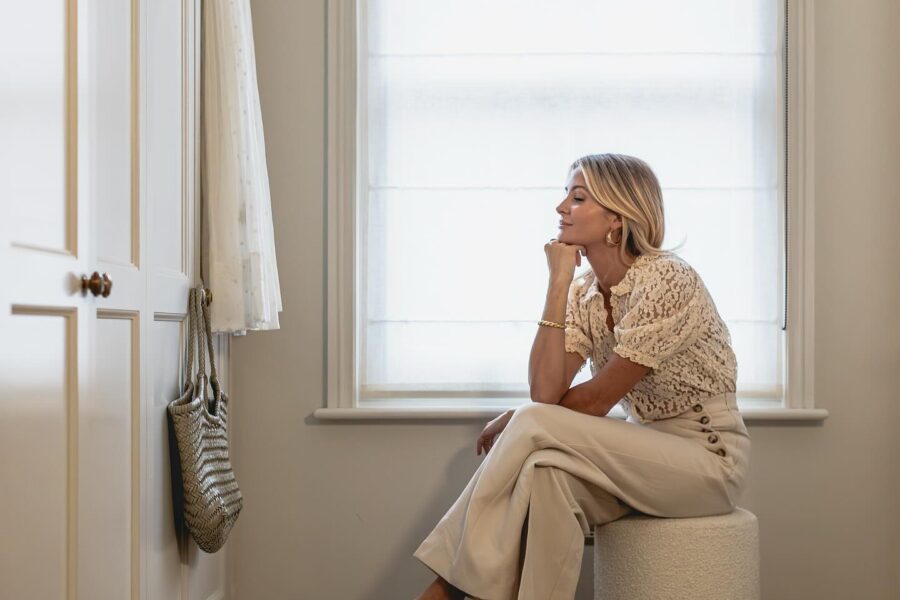 Millie Mackintosh sitting in front of her Tilford style fitted wardrobes created by The Heritage Wardrobe Company