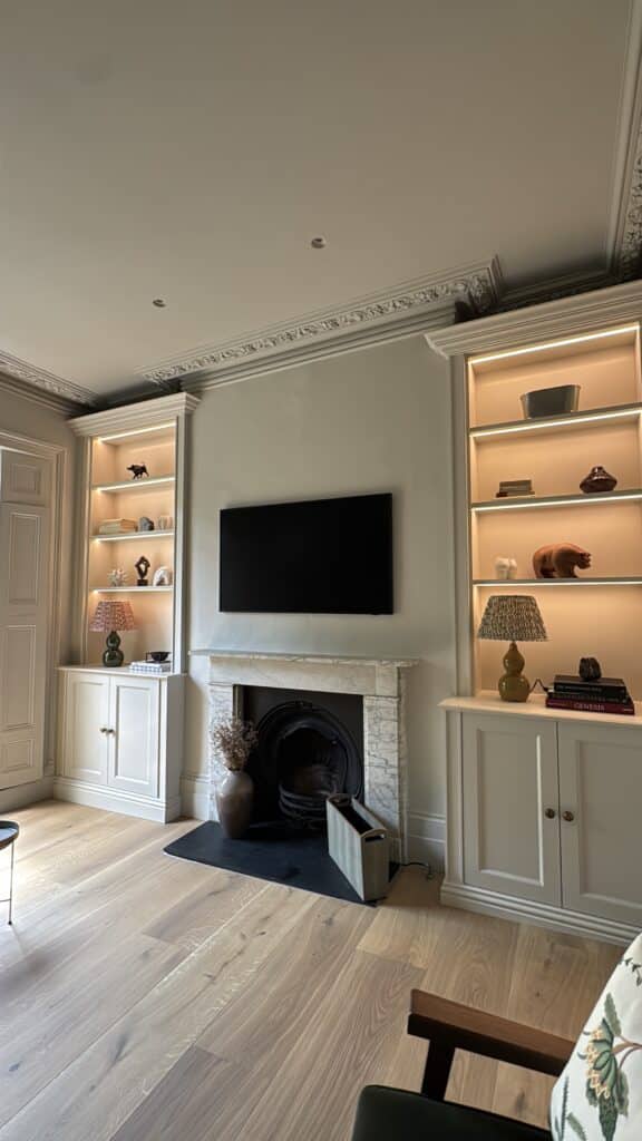 image00021 matching wooden bookcase and cupboard units in alcoves either side of a fireplace in a living room