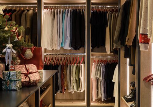 Illuminated custom made walk-in wardrobe with Christmas presents and Christmas tree on island